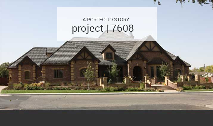 brick and stone tudor with brick and iron fence