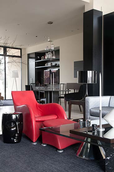 modern family room white walls black bookcases red chair