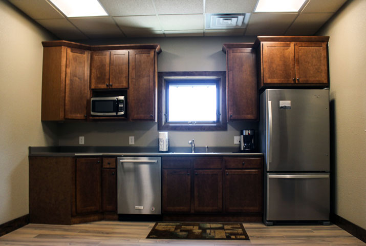 waiting area features kitchenette in dark wood cabinets