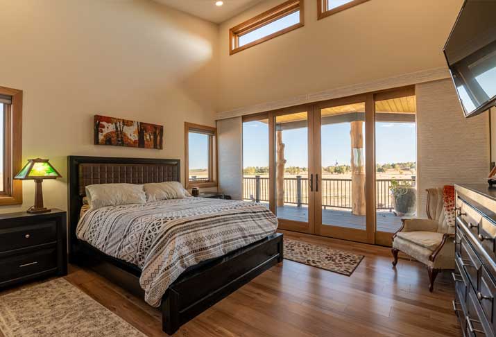 master bedroom has vaulted ceilings and a large double slider to showcase the view