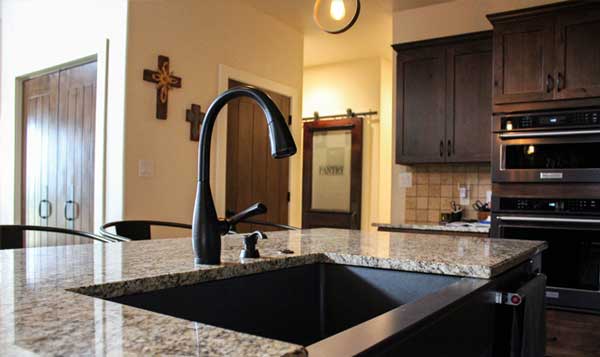 bronze farmhouse sink with oil-rubbed bronze faucet and quartz counter tops